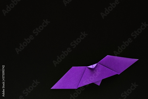 purple origami bat on black background