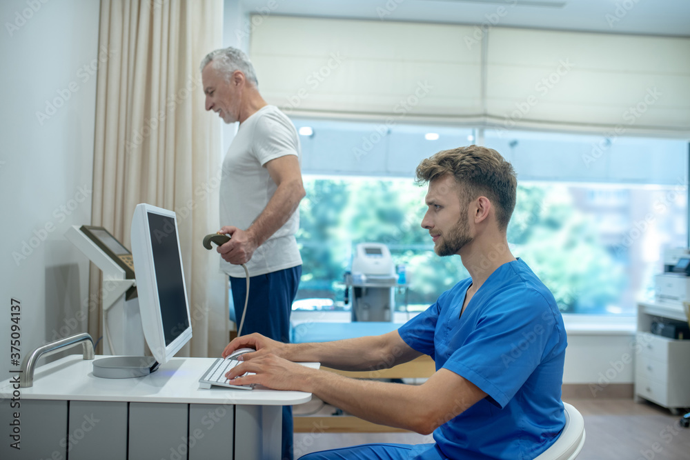 Young doctor assisting mature patient with exercise stress test Young doctor assisting mature patient with exercise stress test