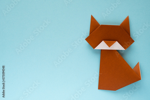 brown origami cat on sky blue background