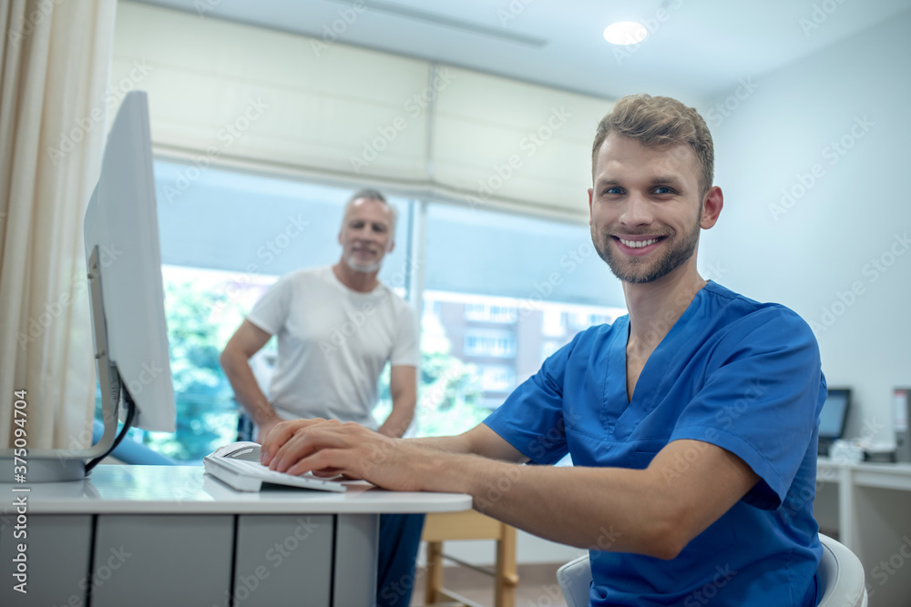 Smiling young doctor and elderly patient in office Smiling young doctor and elderly patient in office