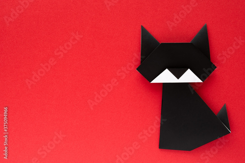 black origami cat on red background