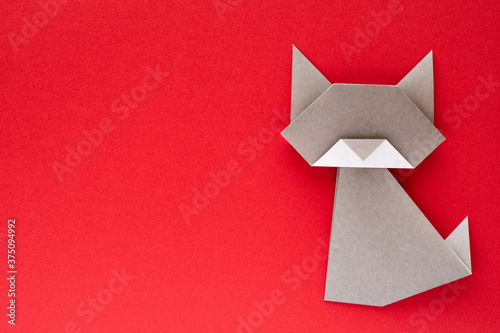 gray origami cat on red background