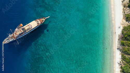Aerial photo taken by drone of tropical seascape and sandy beach with turquoise clear sea and pine trees visited by yachts and sail boats in Caribbean destination island © aerial-drone