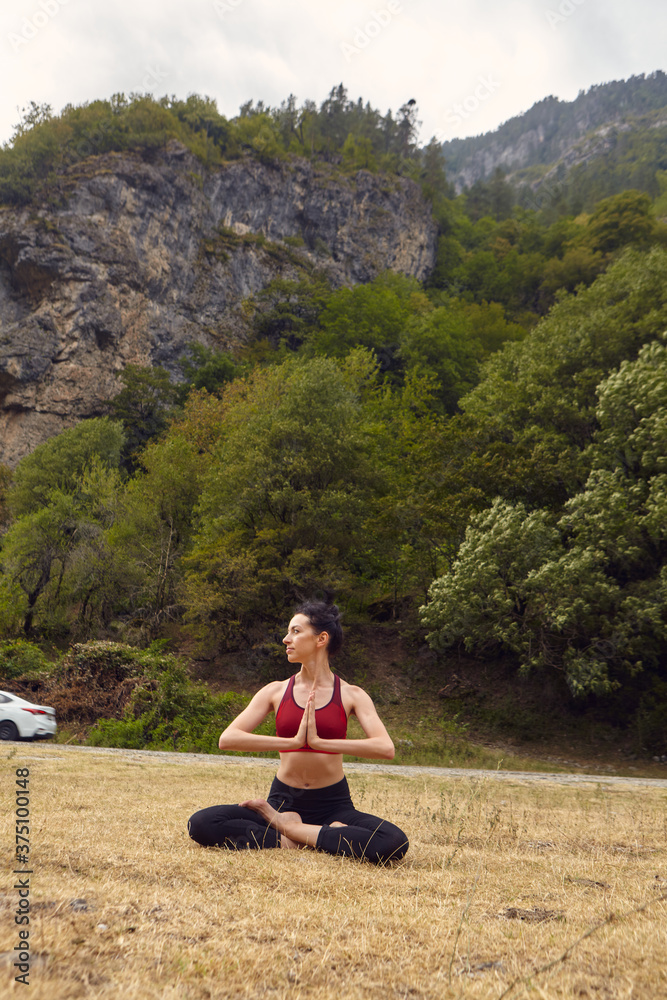 Yoga classes in nature. The concept of playing sports alone. Social exclusion. A woman does yoga in the mountains Yoga classes in nature. The concept of playing sports alone. Social exclusion. A woman does yoga in the mountains