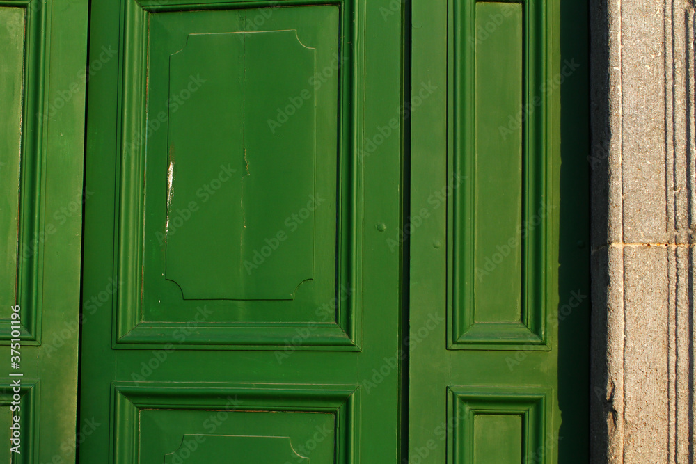 Green wooden door of the Basilica of the Holy Sepulcher in Acquapendente Lazio Italy.