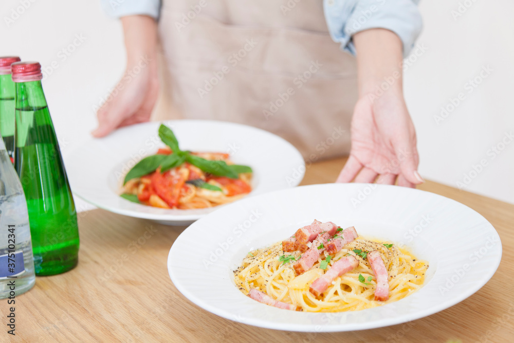 パスタを運ぶ女性の手元