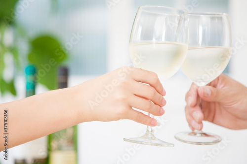 白ワインで乾杯する男女の手元