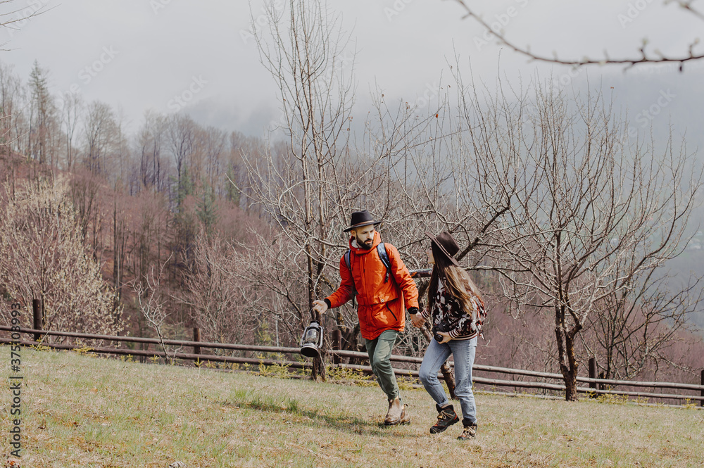 stylish young couple of travelers. Family on a walk in the mountains laid out a tent, prepare breakfast and plan a further itinerary stylish young couple of travelers. Family on a walk in the mountains laid out a tent, prepare breakfast and plan a further itinerary