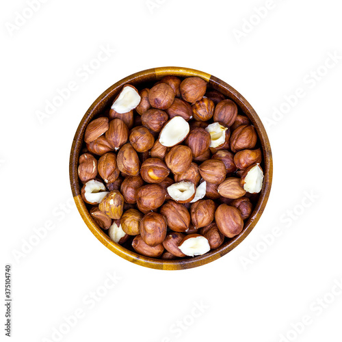 Top view of peeled brown hazelnuts in round wooden bowl isolated on white background.