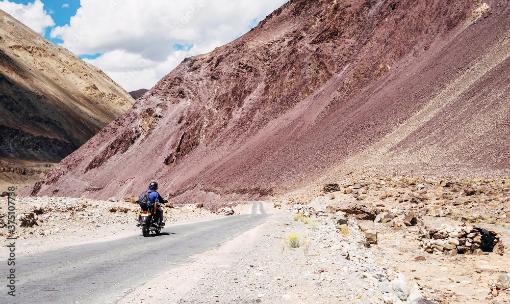 Two friends go by motorcycle by the Leh - Manali highway in high Himalayas Mountain, India.