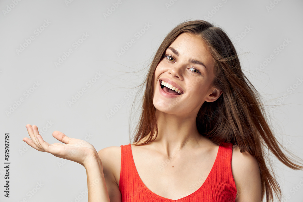 Happy woman in a red T-shirt shows her hand to the side and laughs Happy woman in a red T-shirt shows her hand to the side and laughs