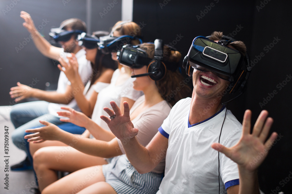 Obraz premium Man is watching exciting movie with friends in VR glasses in entertainment room.