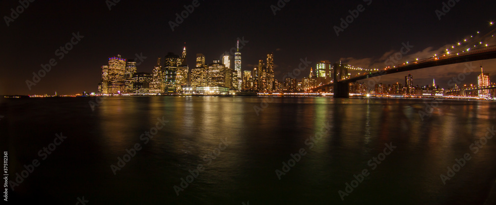Panoramic night shot of New York skyline and the Brooklyn Bridge