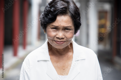 portrait of angry upset unhappy old Asian senior woman with wrinkle skin and dyed black hair