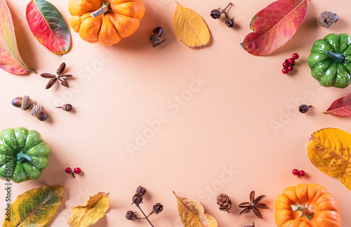 Autumn background decor from dry leaves and pumpkin on pastel paper background. Flat lay, top view with copy space for Autumn, fall, Thanksgiving concept.
