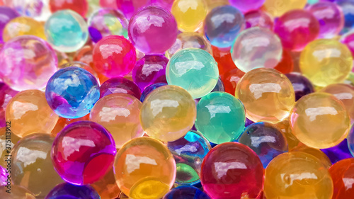 Lots of different colored hydrogel balls. Set of multicolored orbis. Crystal water beads for games. Helium balloons. Can be used as a background. Polymer gel Silica gel.