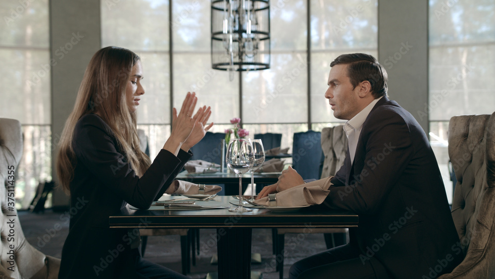 Young couple meeting at restaurant. Business man and woman talking at cafe table