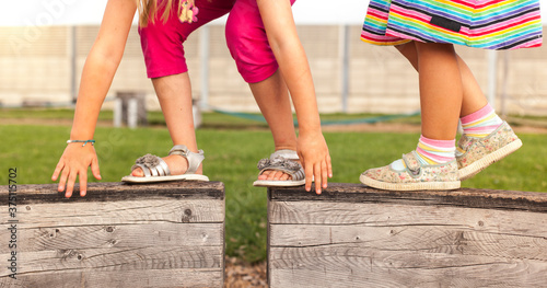 Tableau sur toile Children overcome hurdles and balance on wooden slats