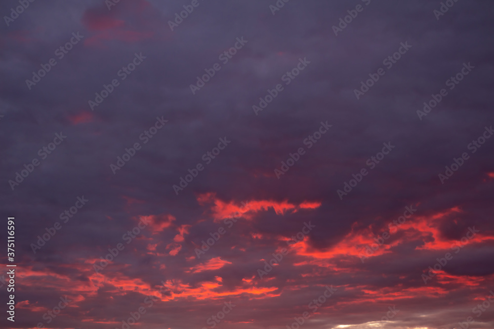 Sunset sky purple with bright orange gleams in the clouds