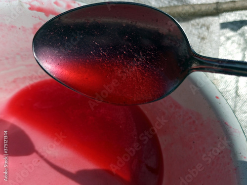 Obraz na płótnie Photo of red jelly and bubbles texture. Red currant jam. Spoon full of jam. Blurry texture w salonie