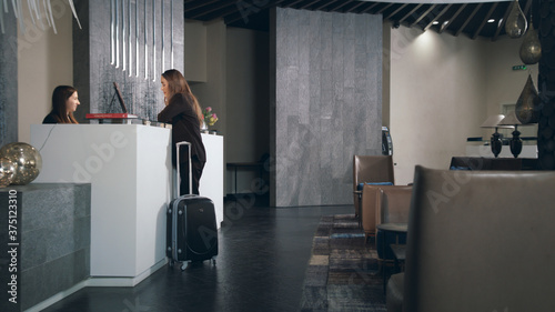 Business woman with travel suitcase arriving in hotel at vacation