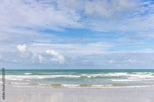 Seascape shot showing blue cloudy sky over a tropical sea on sunny day