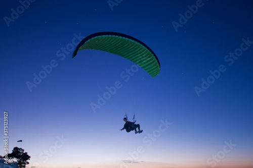 Extreme paraglider flying at night, enjoy the moment. Adventure concept.