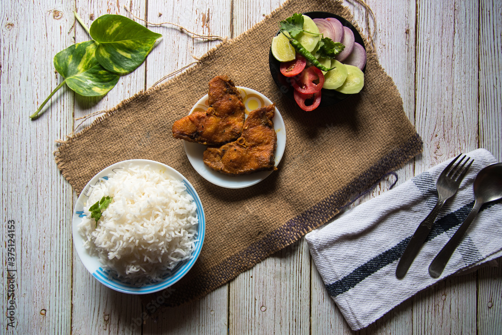 Indian style rice and fried fish with condiments Stock Photo | Adobe Stock