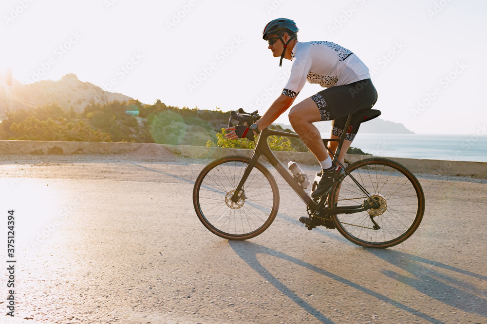 Fototapeta premium Cycling sport athlete man riding on coastal road