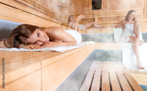 Women pursuing healthy lifestyles relaxing in sauna photo