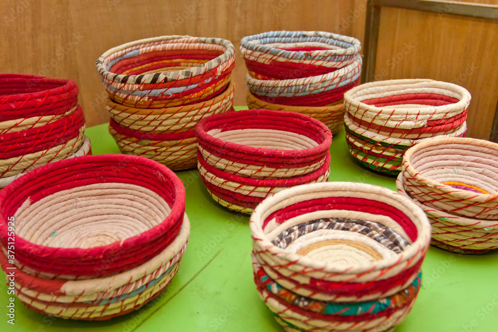 Handmade baskets made of colored cloth and bamboo sticks are on display for sale.