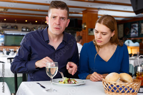 Man and woman unhappy with quality of food in restaurant