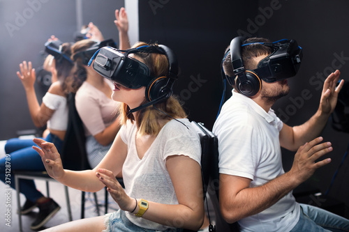 Young happy people having fun with a new technology of a vr headset goggles