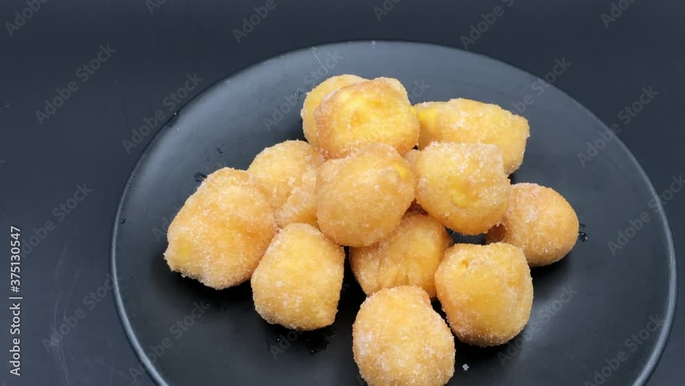 Italian deep fried cake with custard on black dish background Italian deep fried cake with custard on black dish background