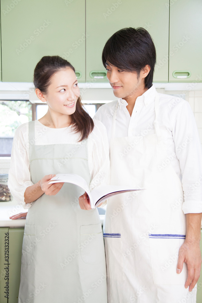 レシピ本を見る夫婦 レシピ本を見る夫婦