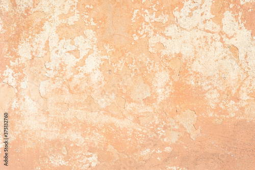 beige cracked plaster texture, with elements of rubbed white paint. Pastel tone textured street wall