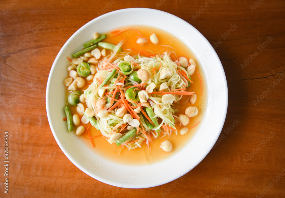 Thai food papaya salad with macadamia nuts on top on white plate Healthy food Thai food papaya salad with macadamia nuts on top on white plate Healthy food
