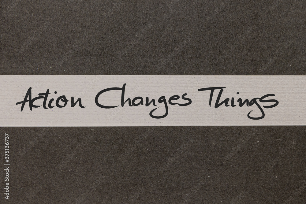 Fototapeta premium White and Grey coloured paper background with Action Changes Things motivational handwritten message