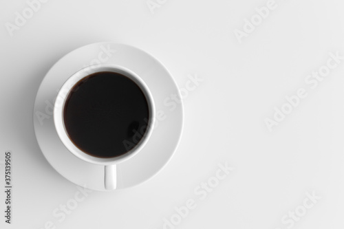 Top view of a cup of coffee on a white table with blank copy space.