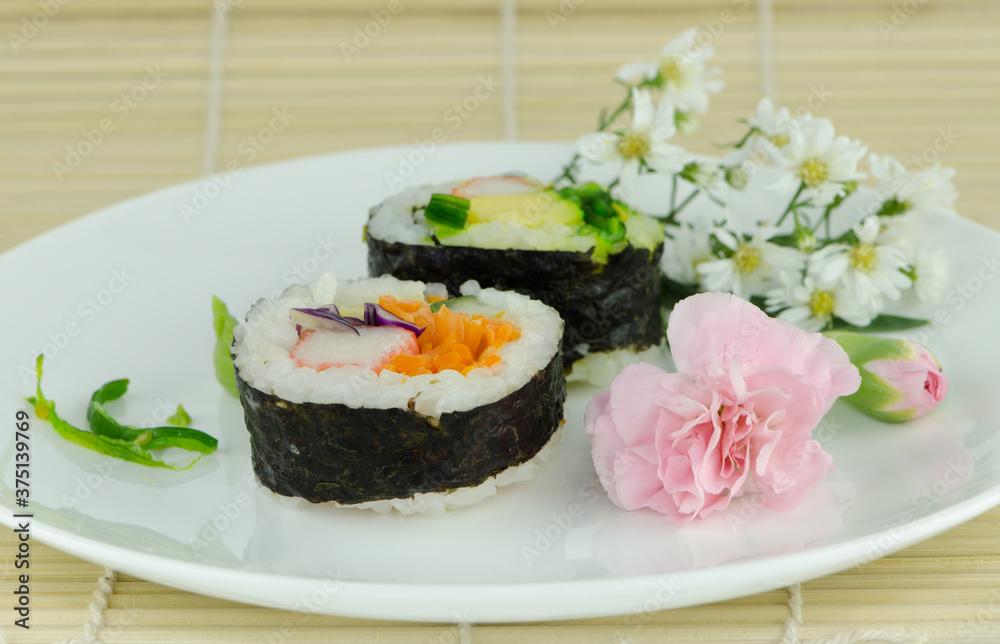 sushi,Japanese food put on the white dish on plate the bamboo. sushi,Japanese food put on the white dish on plate the bamboo.