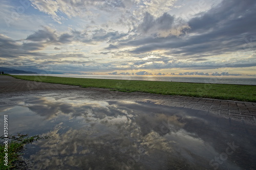 Beautiful sunset at the sea and reflection on puddle in Japan