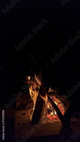 Obraz na płótnie Заголовок: Camp fire in the night. Bonfire. Flame and fire sparks on dark background. Black copy space.
w salonie