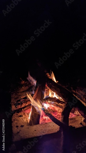 Obraz na płótnie Заголовок: Camp fire in the night. Bonfire. Flame and fire sparks on dark background. Black copy space.
w salonie