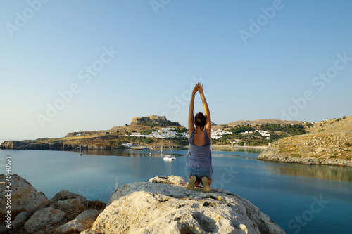 Jeune femme s'étirant face à Lindos