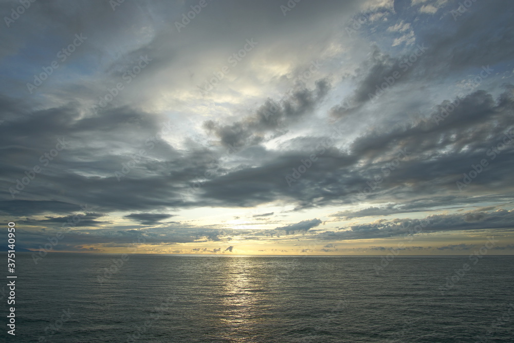 Sunset. Beautiful sunset at Japanese sea. Gold cloudy sky sunset. Picture Sea sunset.