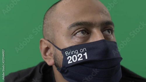 Adult Male Wearing Bring It On 2021 Cotton Mask Looking Off Camera. Green Screen, Locked Off photo