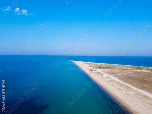 Aerial view of exotic long sand beach with sea on both sides 