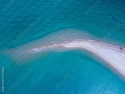 Aerial view of exotic long sand beach with sea on both sides 