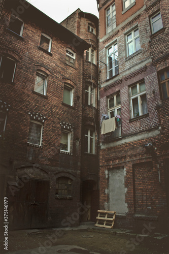 small gloomy courtyard with old houses. Urban architecture © tillottama