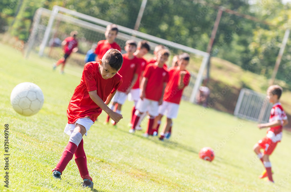 Obraz premium Young boy shooting soccer ball